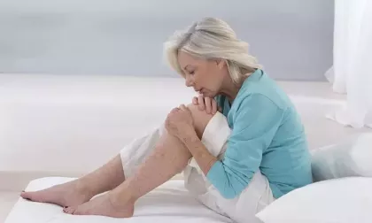 older woman holding knee in pain