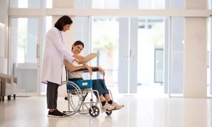 patient reading in a wheelchair