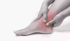 holding ankle in pain