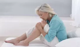 older woman holding knee in pain